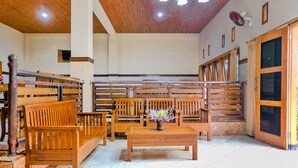 A spacious room with wooden benches and tables, a tiled floor, and a wooden ceiling.