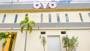A building with the sign "OYO" on the facade, featuring a simple architectural style with a flat roof and a series of windows. - OYO 2614 Demasto Homestay (Jember)
