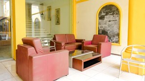 A modern living room with a sofa set, a coffee table, and a chair. - OYO 2614 Demasto Homestay (Jember)