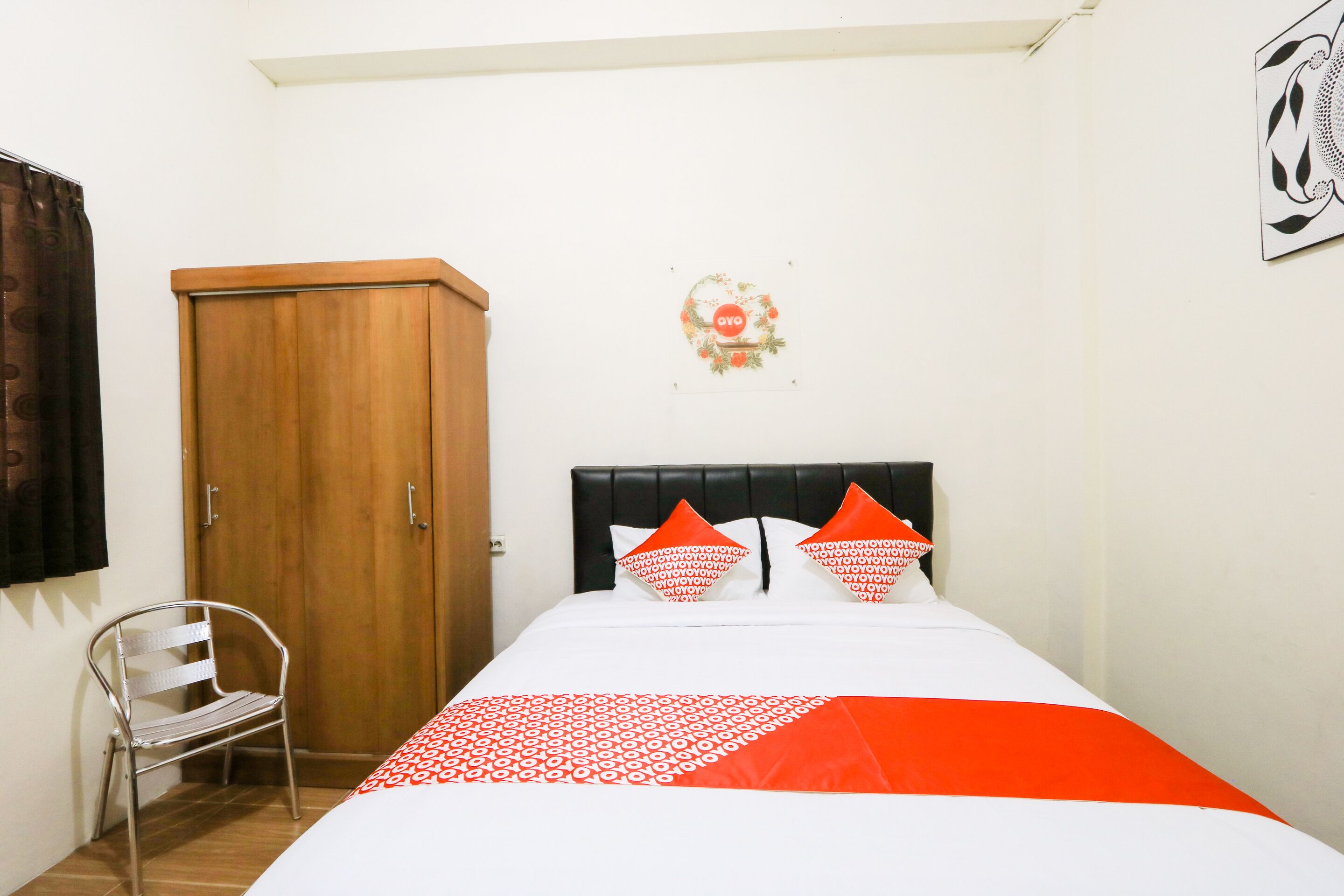 A bedroom with a bed, a wardrobe, and a chair.