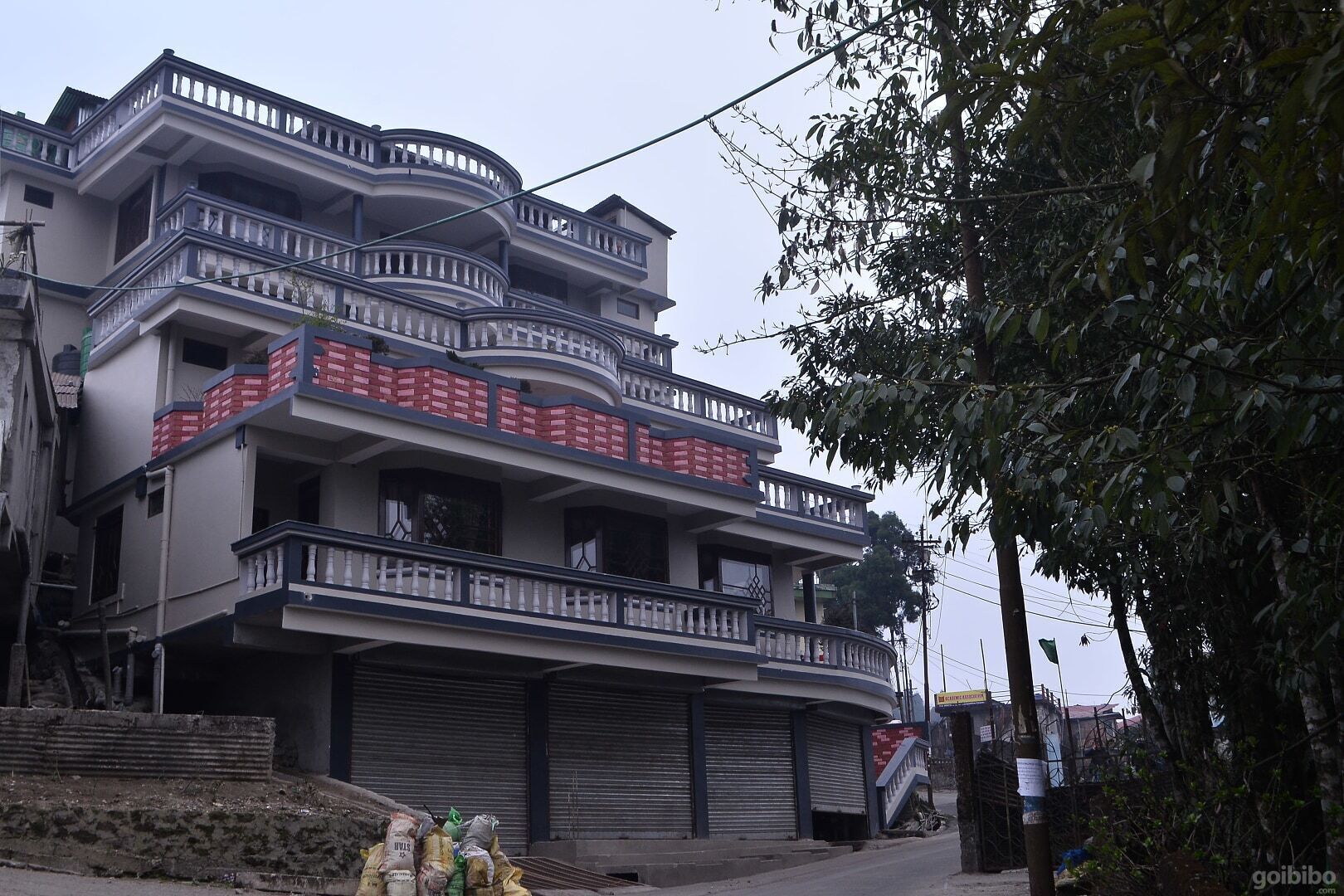 Un edificio a più piani con balconi, un garage e una scala che conduce all'ingresso.