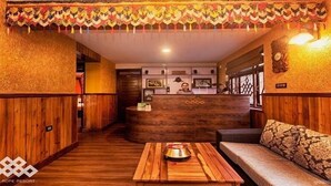 Un intérieur en bois comprenant un comptoir d’accueil, un canapé et une table agrémentée d’un objet décoratif.