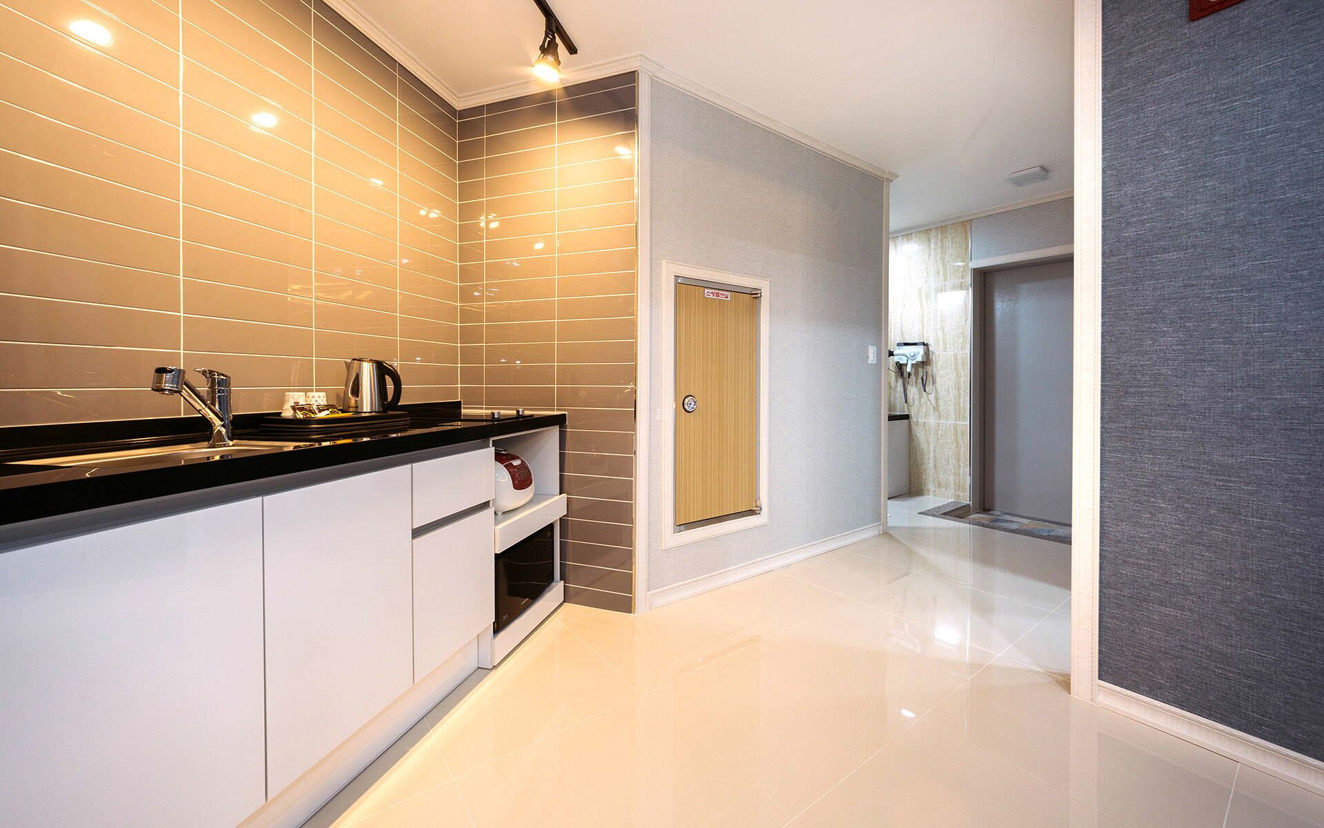 A modern kitchen with a black countertop, stainless steel appliances, and a tiled backsplash.