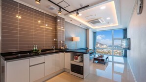 A modern kitchen with a large window, a built-in oven, and a view of the city.
