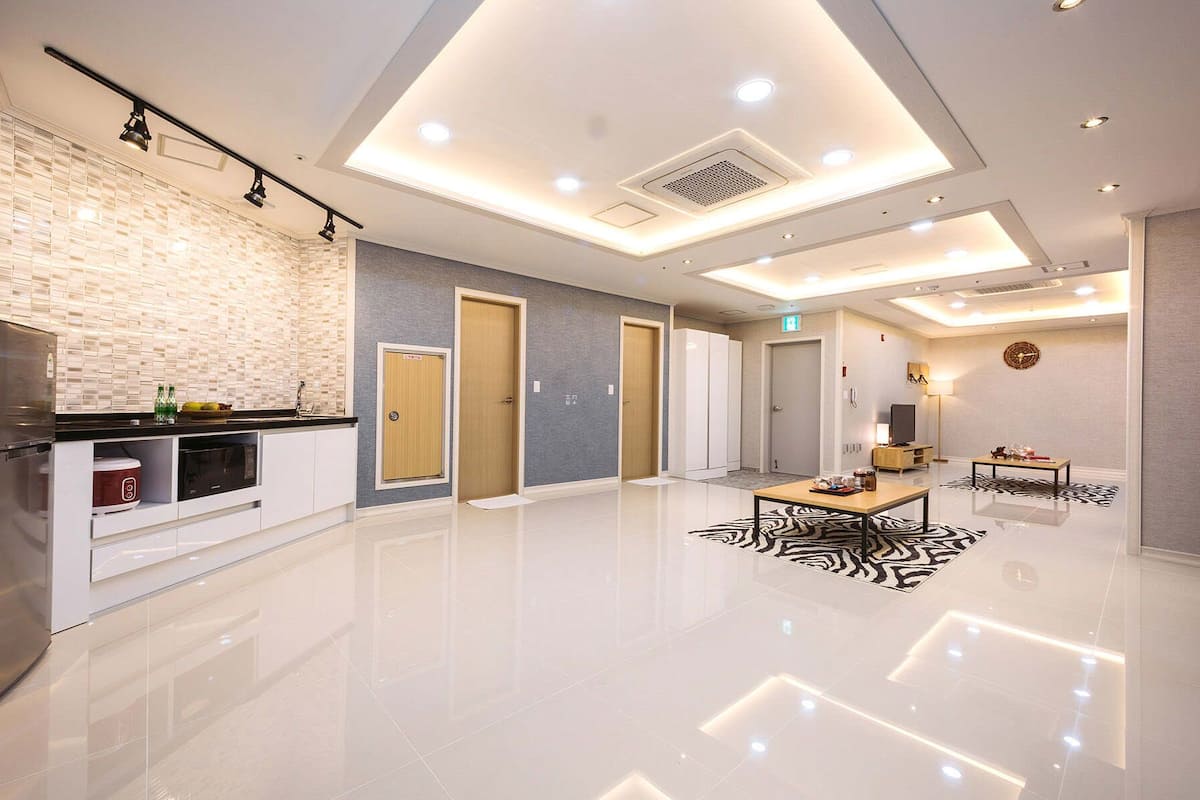 Quarto de hotel moderno com cozinha, sala de jantar e área de estar.