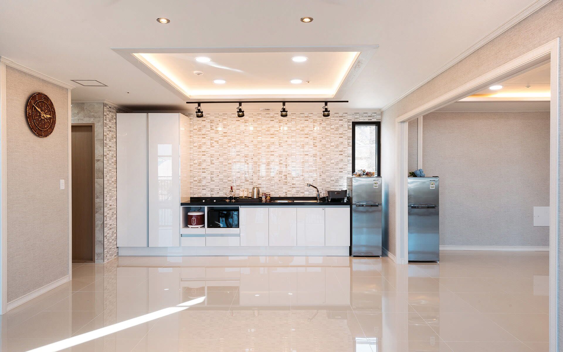 Una cocina moderna con una isla central, electrodomésticos integrados y una luz empotrada en el techo.