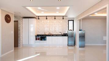 Una cocina moderna con una isla central, electrodomésticos integrados y una luz empotrada en el techo.