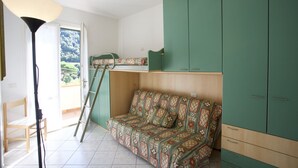 A room with a sofa, a ladder, a wardrobe, and a lamp. - BOUGAINVILLEA PRIMO PIANO (Marciana)