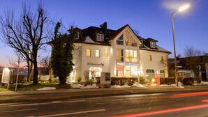Un hotel de estilo arquitectónico tradicional, con una entrada destacada, una señalización visible y una fachada bien iluminada.