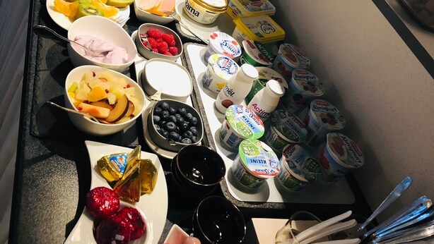 Un bufé con una variedad de alimentos, incluyendo frutas, quesos, carnes y productos lácteos.