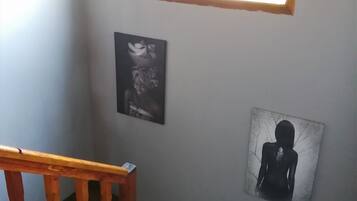 Una escalera con barandas de madera y un pequeño ventanal en la parte superior.