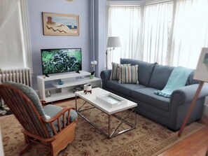 Relax in style with a large flat-screen TV, comfortable sofa, and a cozy reading nook.