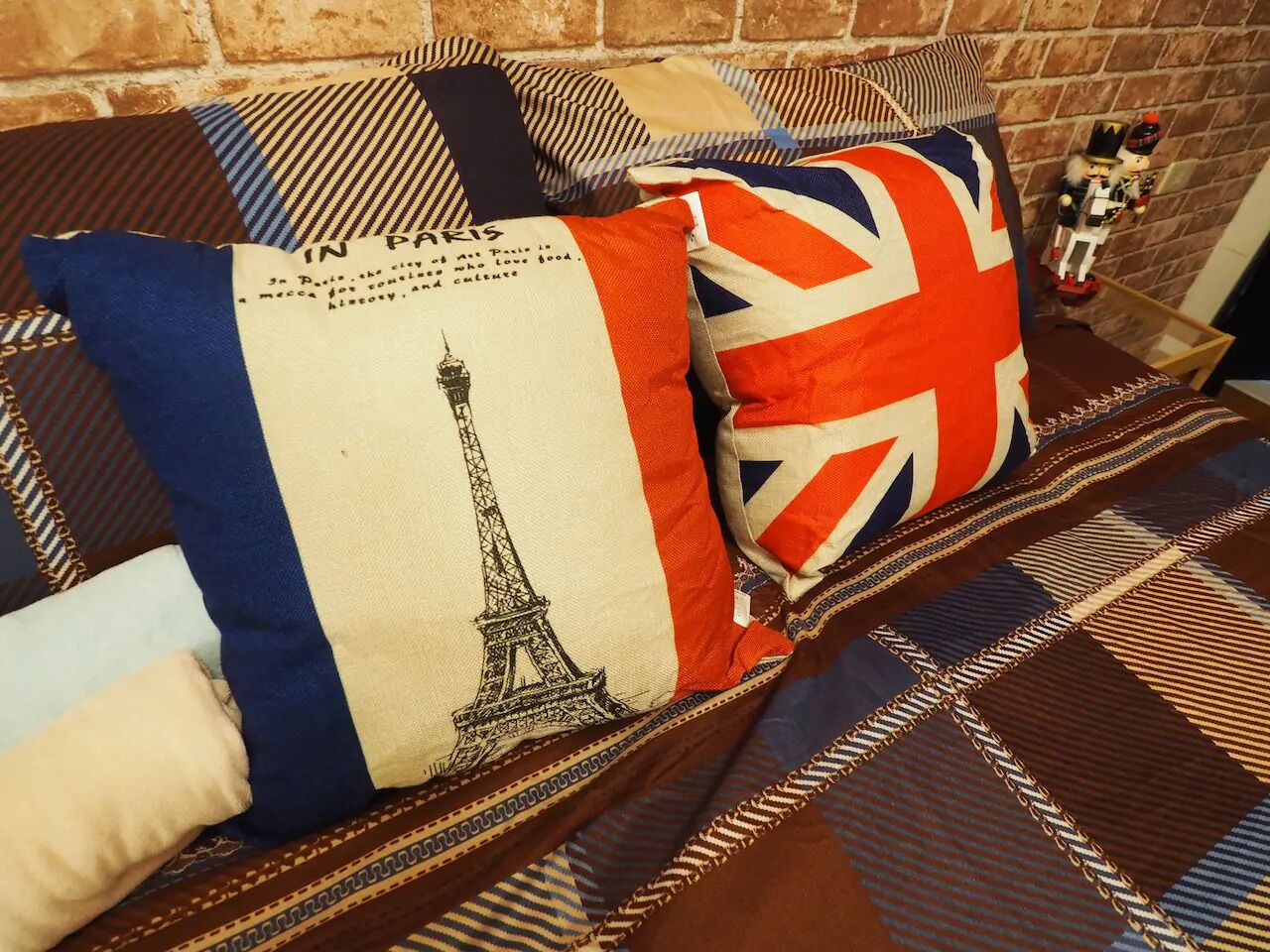 A sofa with patterned cushions and a decorative nutcracker figure.