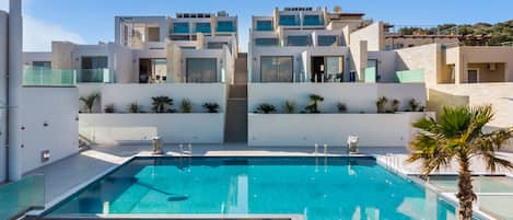 En säsongsöppen utomhuspool, parasoller och solstolar