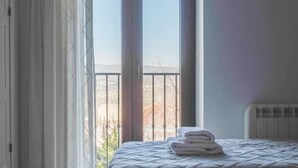 Une chambre avec un lit, un radiateur et une vue sur l’extérieur.