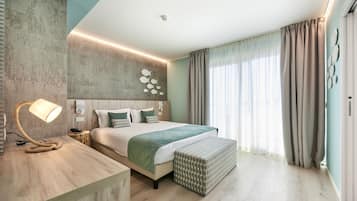 A modern bedroom with a large bed, bedside lamp, and a wooden bedside table.