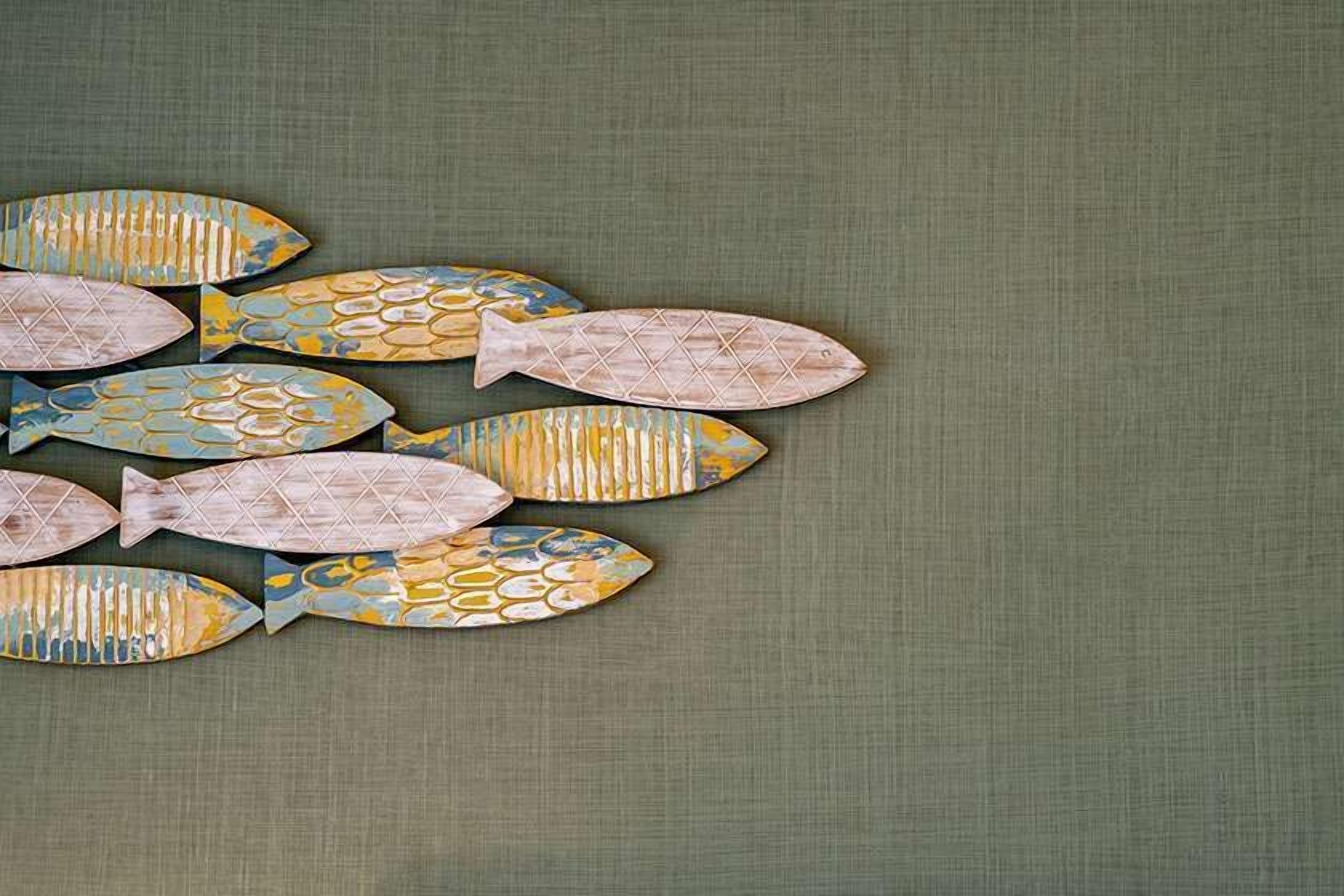 A collection of fish-shaped decorations on a textured wall.