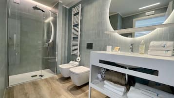 Un bagno moderno con cabina doccia in vetro, un water bianco e un mobile lavabo con specchio.