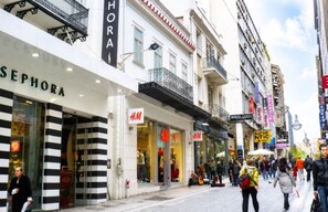 Een straat met verschillende winkelgefaciliteiten, waaronder Sephora en H&M.