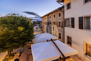A narrow street with outdoor seating and a tree. - Ostarie Vecjo Friûl (Sedegliano)