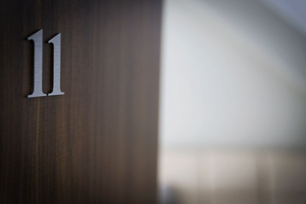 Un gros plan d’une porte en bois portant le numéro « 11 ».