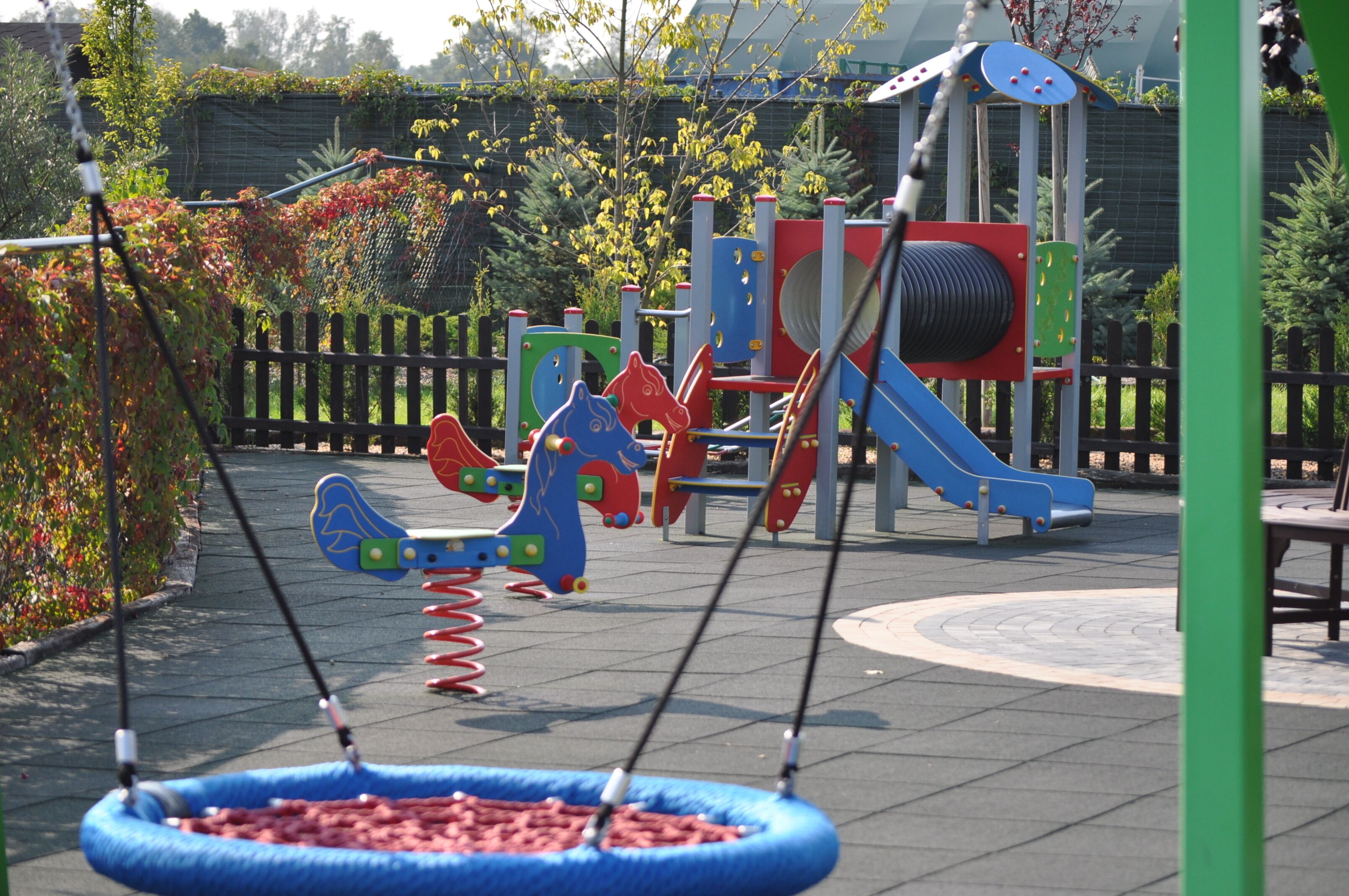 A playground with swings, a slide, and a climbing structure.