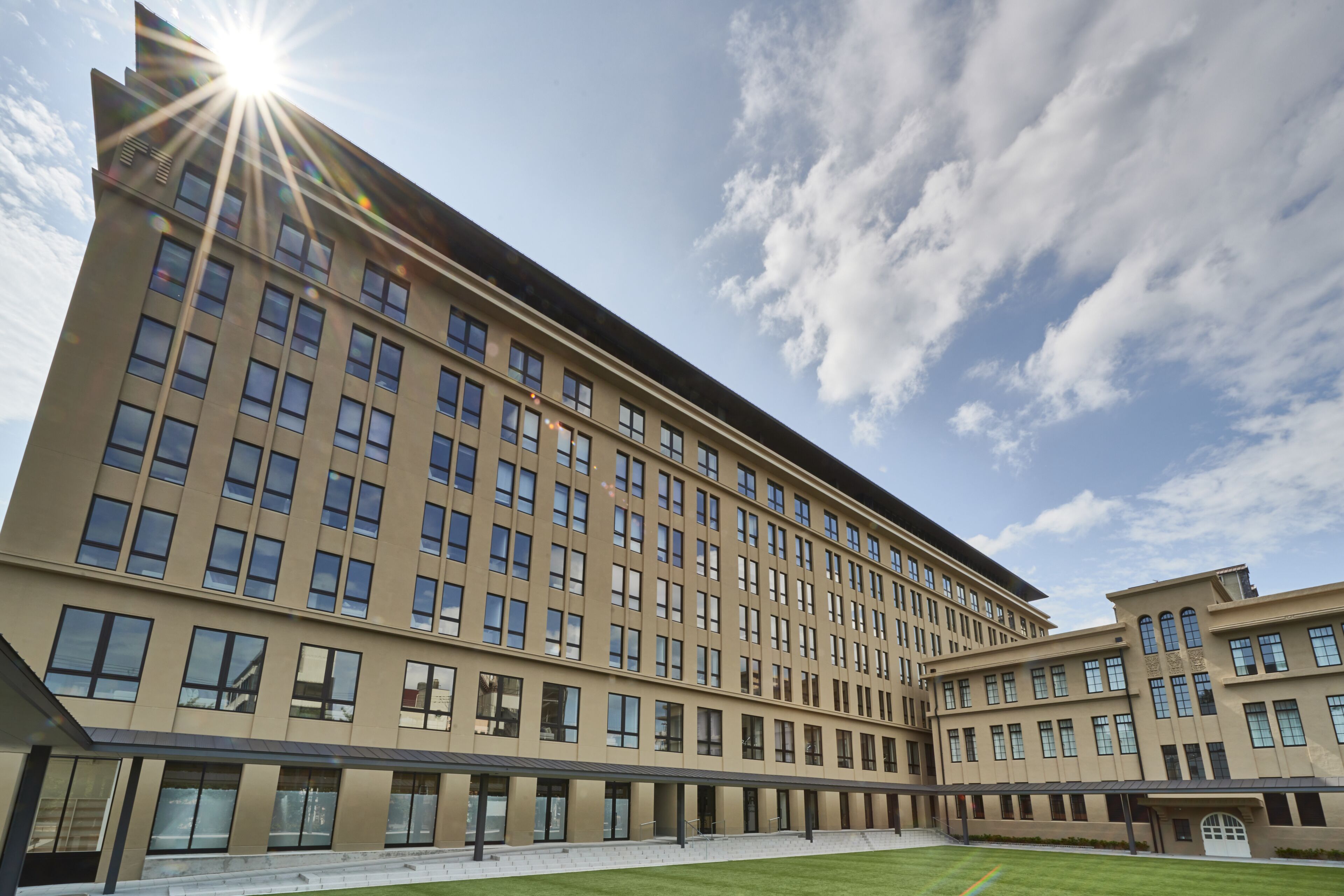 A large, modern hotel with a long facade, multiple floors, and a covered outdoor area.