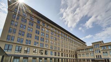 A large, modern hotel with a long facade, multiple floors, and a covered outdoor area.