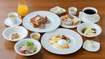 Una colazione con diversi piatti e bevande su un tavolo di legno.