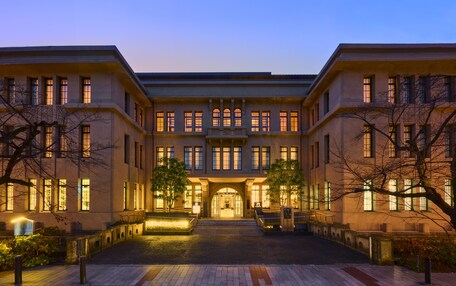 A large, symmetrical building with a central entrance, multiple windows, and a well-lit facade.