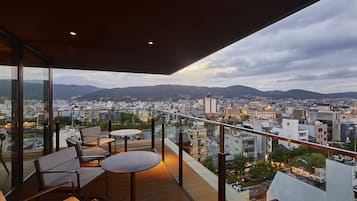 A balcony with seating and a city view.