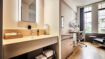 A modern bathroom with a large mirror, a wooden vanity, and a built-in shower.