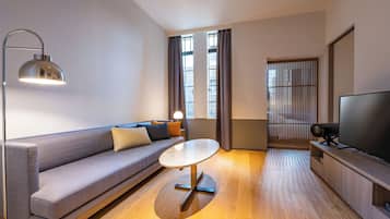 A modern living room with a sofa, a round table, a floor lamp, a TV, and a sliding door.