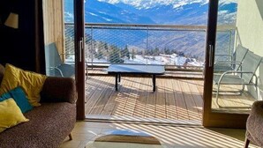 Habitación con vista a montañas nevadas a través de un ventanal.