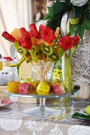 A glass vase with a floral arrangement and a glass dish with fruit skewers. - Bellaria Residence (Giurdignano)