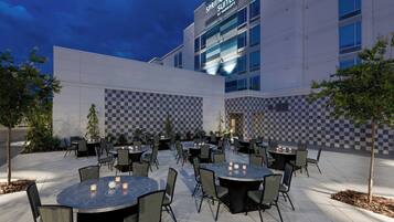A hotel exterior with outdoor seating and a checkered wall pattern.