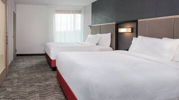 Een hotelkamer met twee bedden, een vloerkleed, een raam met dunne gordijnen en een modern wandontwerp.