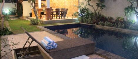 Alberca al aire libre y camastros