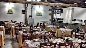 Un restaurante con varias mesas preparadas para comer, con manteles a cuadros y sillas de madera.