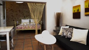 A room with a bed, a sofa, a small table, and a chair. - Yro Studios (Chania)