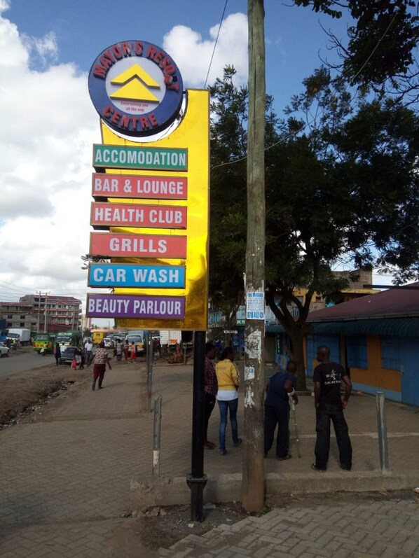 A signboard for Mayor's Resort Centre listing amenities such as accommodation, bar & lounge, health club, grills, car wash, and beauty parlour. - Mayors Resort Centre (Nairobi)