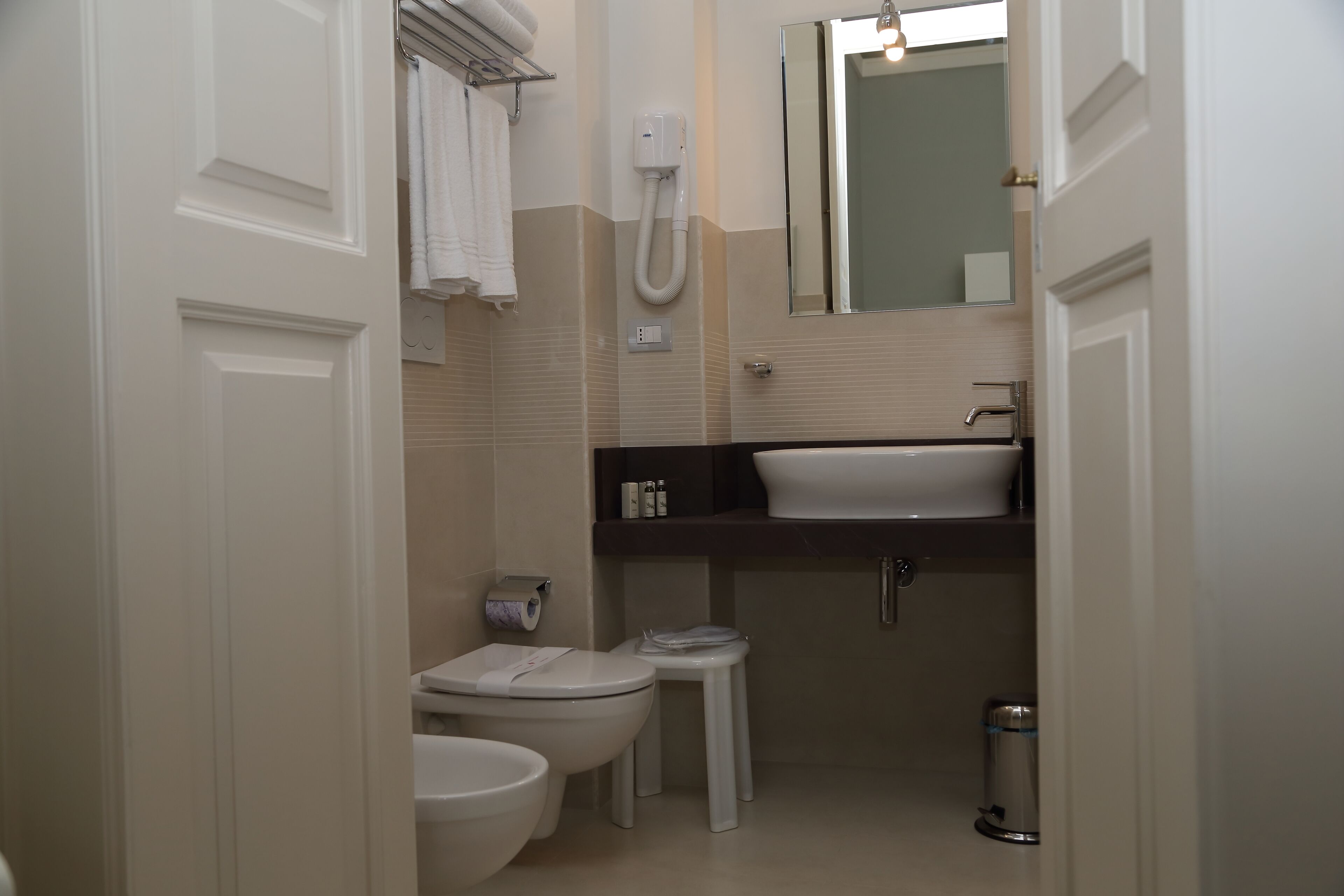 Un baño pequeño con inodoro, bidé y lavamanos.