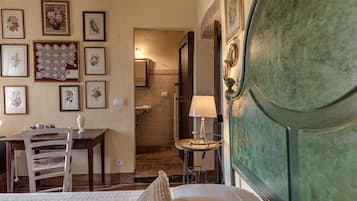 Una stanza con un letto, una scrivania, una sedia, un tavolo, una lampada e una porta.