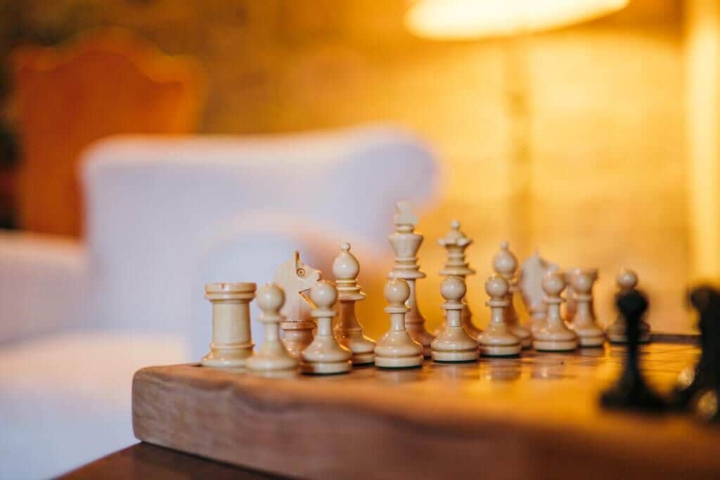 Een schaakbord met stukken op een houten ondergrond.
