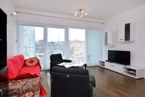 Relax in this stylish living room with a sofa, armchair, and flat-screen TV.