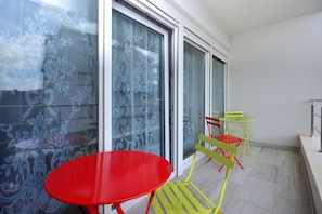 Enjoy a simple seating area with a table and two chairs, offering a view of the outdoors through glass doors.