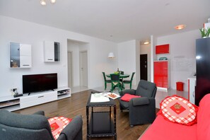 Relax in this stylish living room with a flat-screen TV, dining area, and fully equipped kitchen.