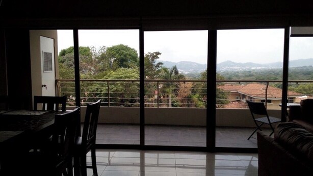 A room with a balcony, a dining table, and chairs. - Luxurious fully furnished located in one of the most exclusive and safe areas (San salvador)