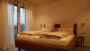 A bedroom with a bed, a window with curtains, and a small stool. - Rustic-style vacation home for 2 people (Lauterhofen)