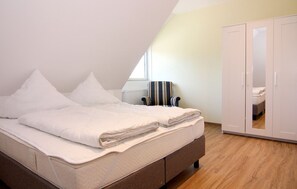 A bedroom with a bed, a chair, and a wardrobe. - Ferienhof Neuendorf (Luetow)